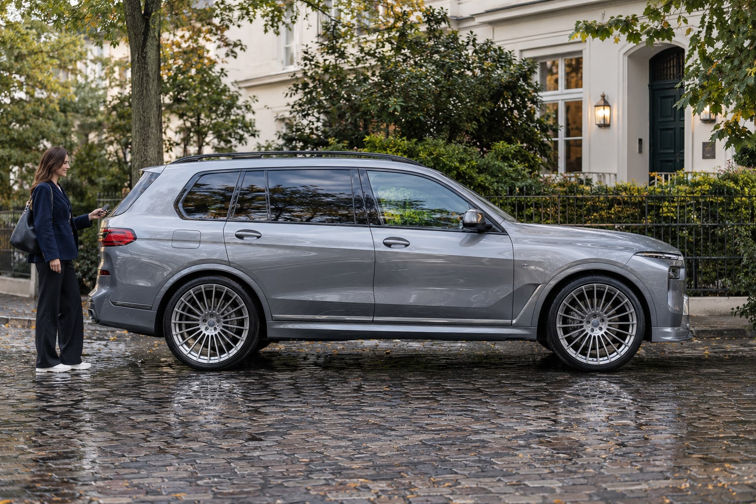 Alpina XB7 Kfz-Versicherung: Individuellen SUV-Wert, Reisebedarf und Fahrer passend erfassen. Silberner großer SUV mit Frau auf einer Einfahrt: Alpina XB7 Kfz-Versicherung