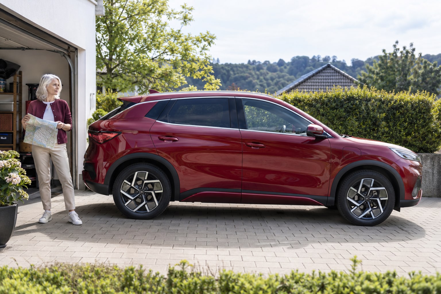 BYD Kfz-Versicherung: Ähnliche Modellnamen und unterschiedliche Antriebe vor dem Tarifvergleich richtig zuordnen. Roter Elektro-SUV mit Frau vor einem Wohnhaus: BYD Autoversicherung