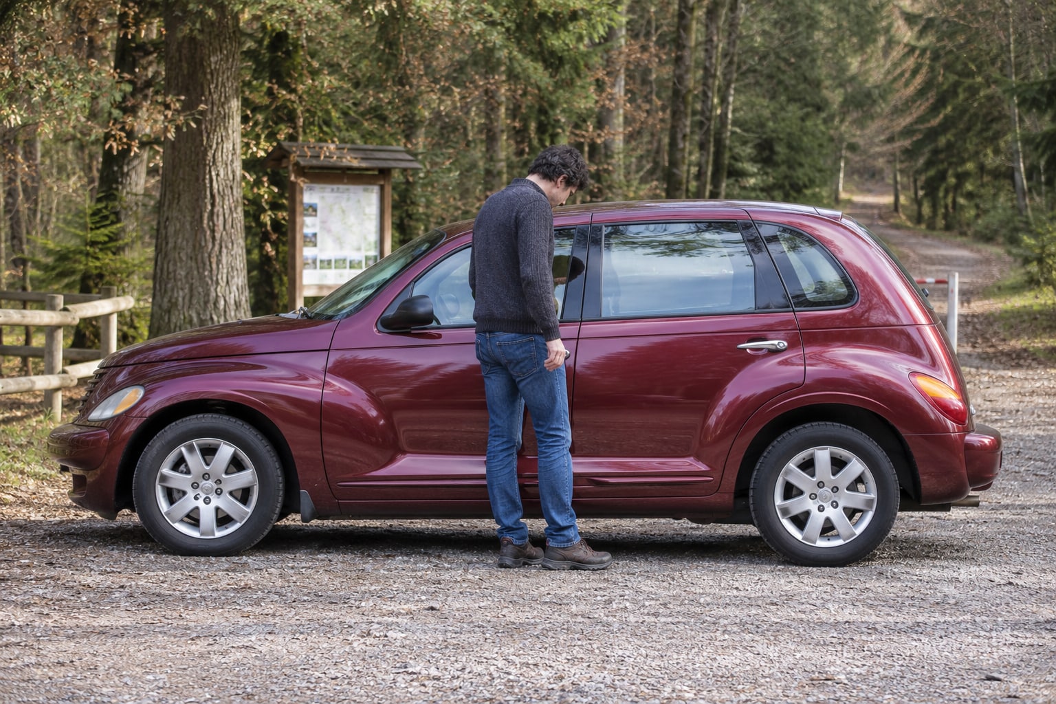 Chrysler PT Cruiser Kfz-Versicherung: Welche Kasko passt zum gebrauchten Retroauto oder Cabrio? Roter Retro-Kompaktwagen am Waldrand: Chrysler PT Cruiser Autoversicherung mit passender Karosserie