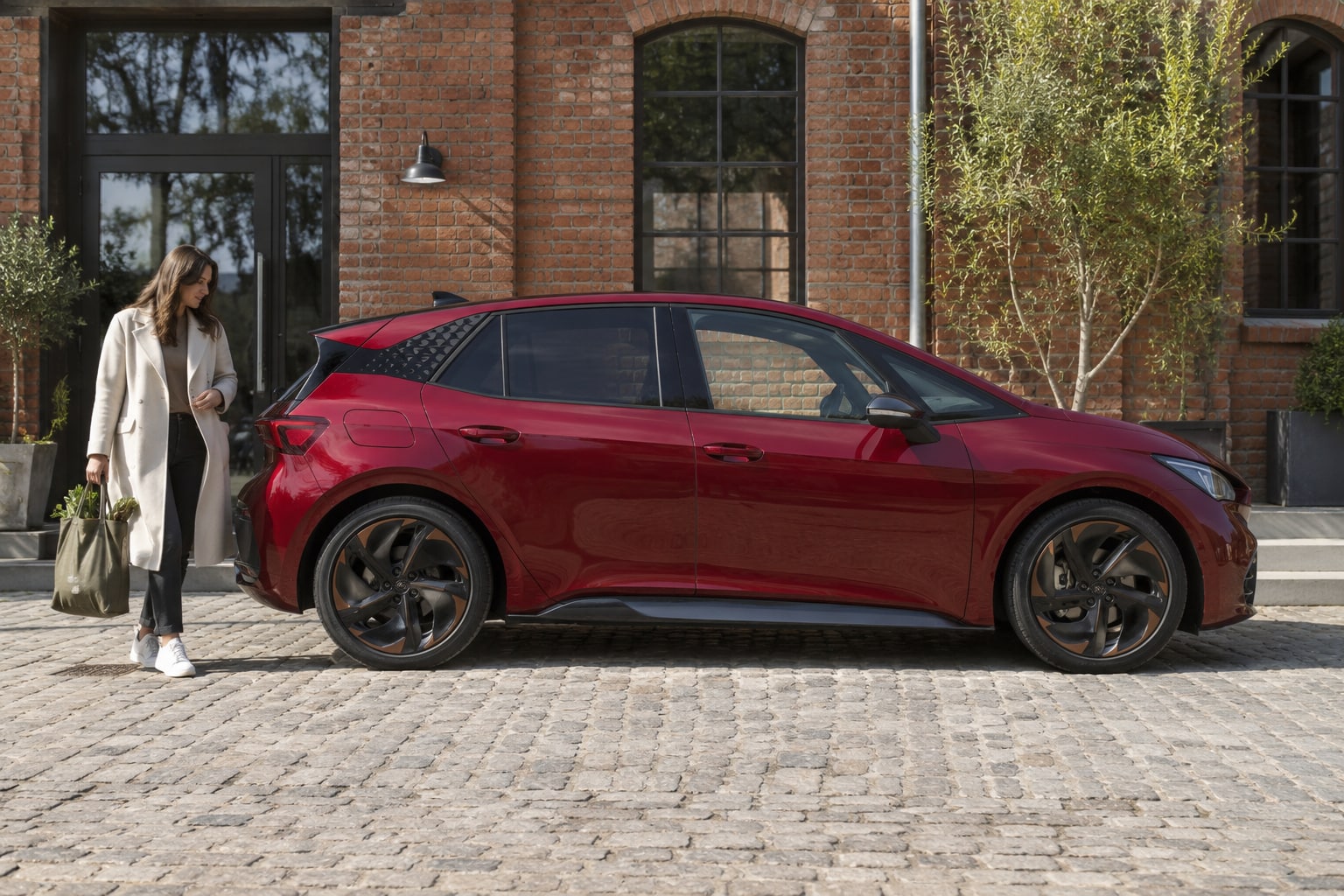 Cupra Born Kfz-Versicherung: Welche Elektro-Leistungen passen zu Batterievariante und täglicher Nutzung? Roter Elektro-Kompaktwagen auf einem Stadtplatz: Cupra Born Autoversicherung und Elektro-Kasko