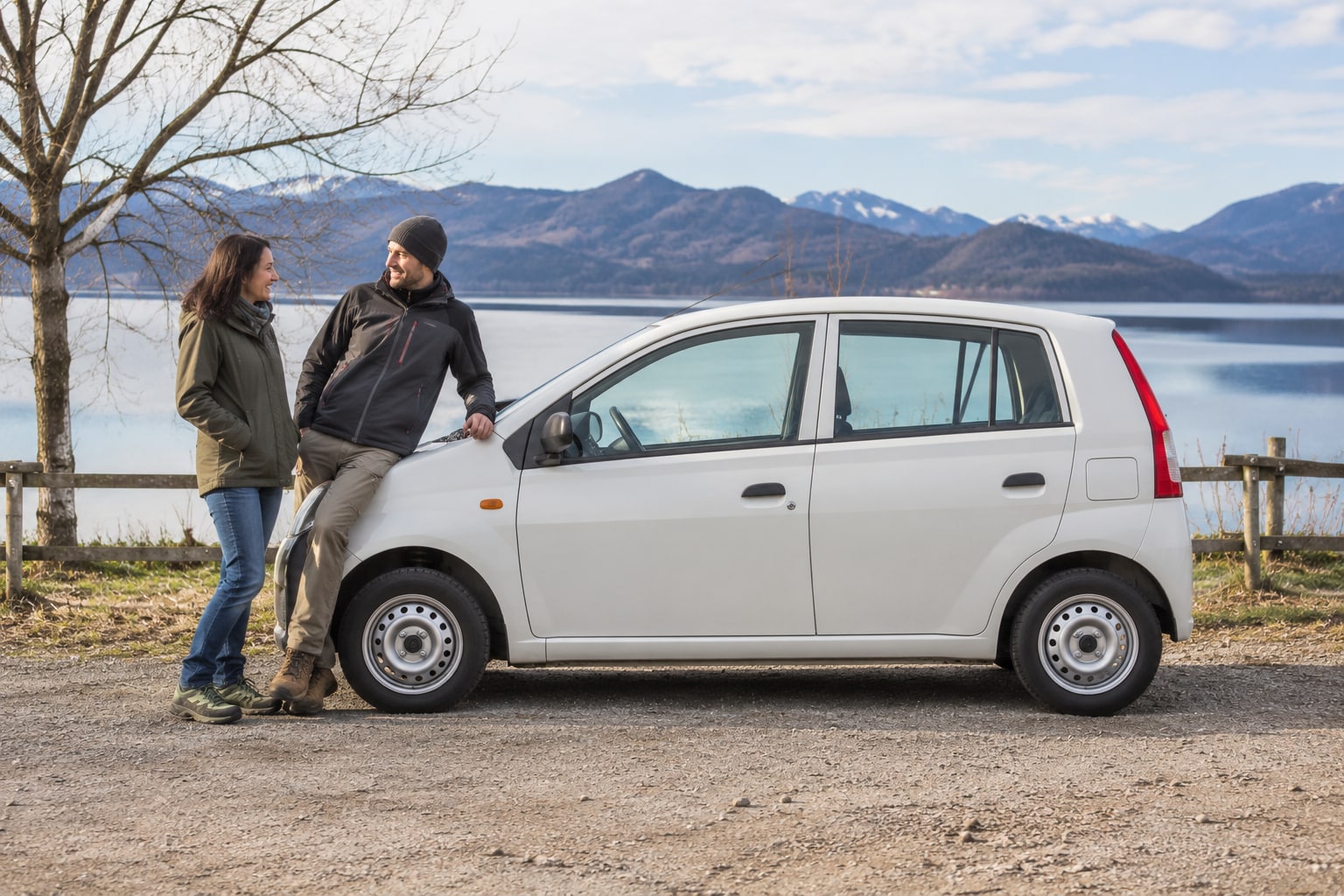 Weißer Kleinstwagen am Bergsee: Daihatsu Autoversicherung für ältere Alltagsautos