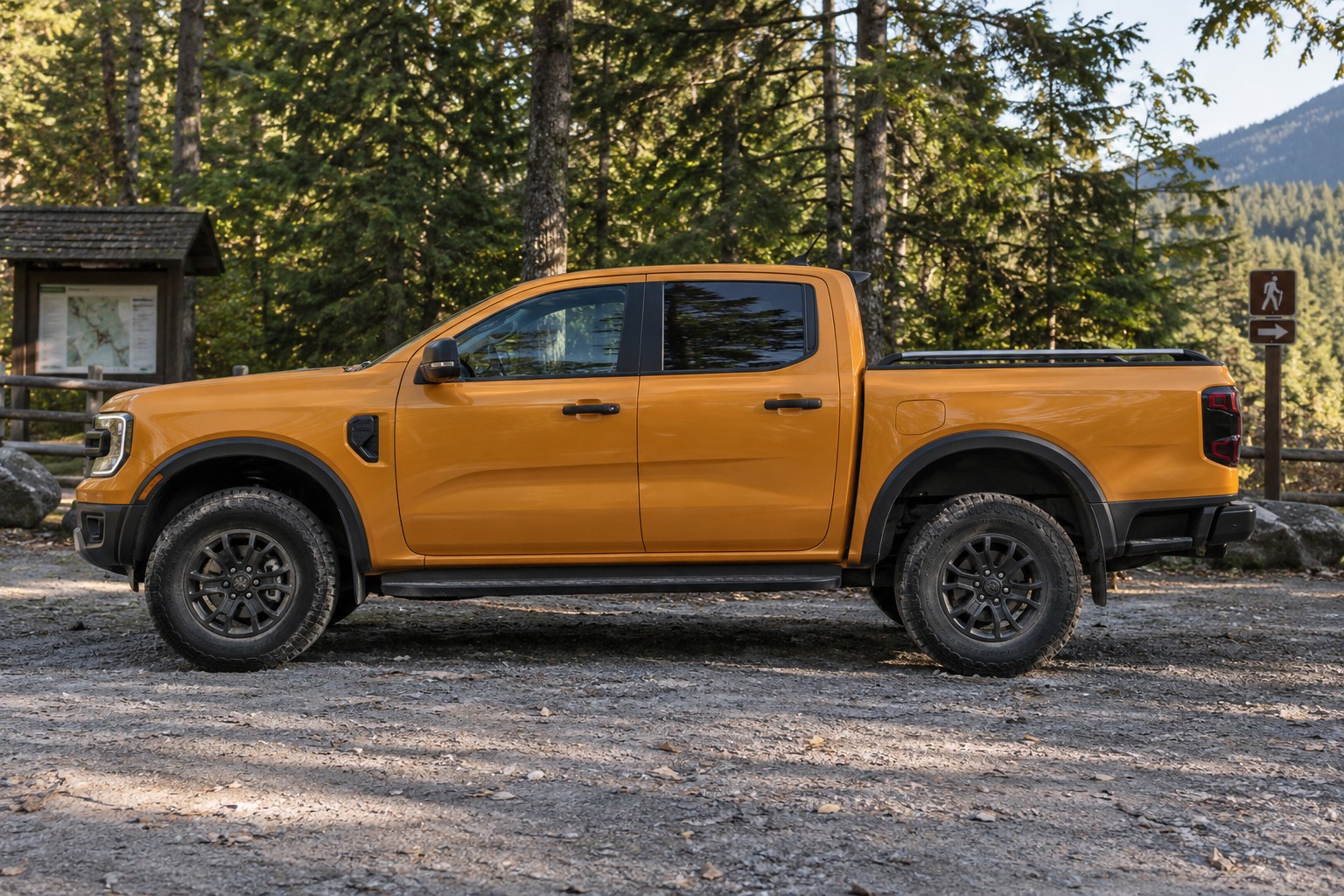 Ford Ranger – Pickup, Raptor und Zulassungsart Orangefarbener Ford Ranger mit Doppelkabine im Seitenprofil an einem Waldparkplatz