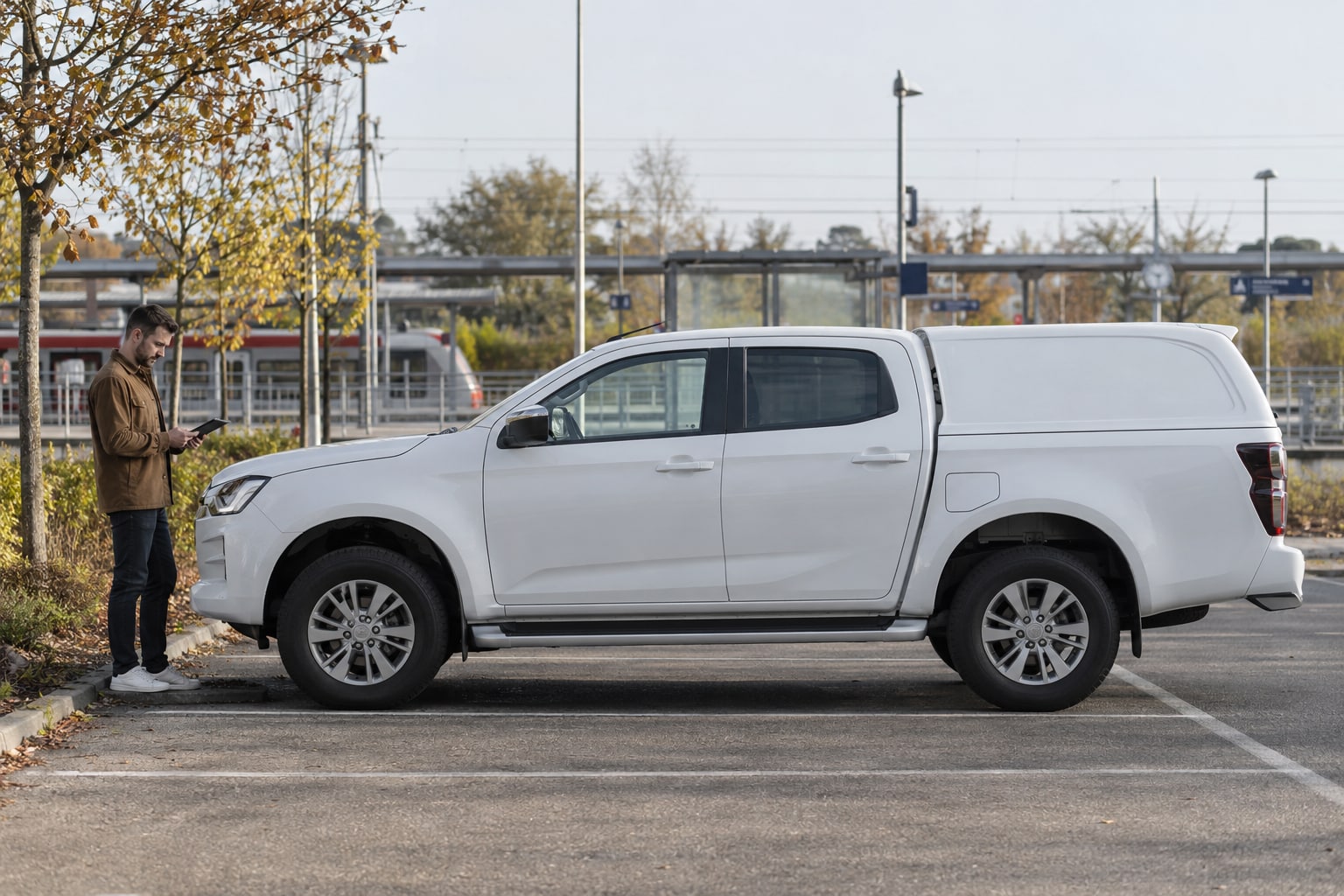 Isuzu Kfz-Versicherung: Pick-up, Nutzfahrzeug und transportierte Ausrüstung voneinander abgrenzen. Weißer Pickup auf einem befestigten Parkplatz: Isuzu Autoversicherung