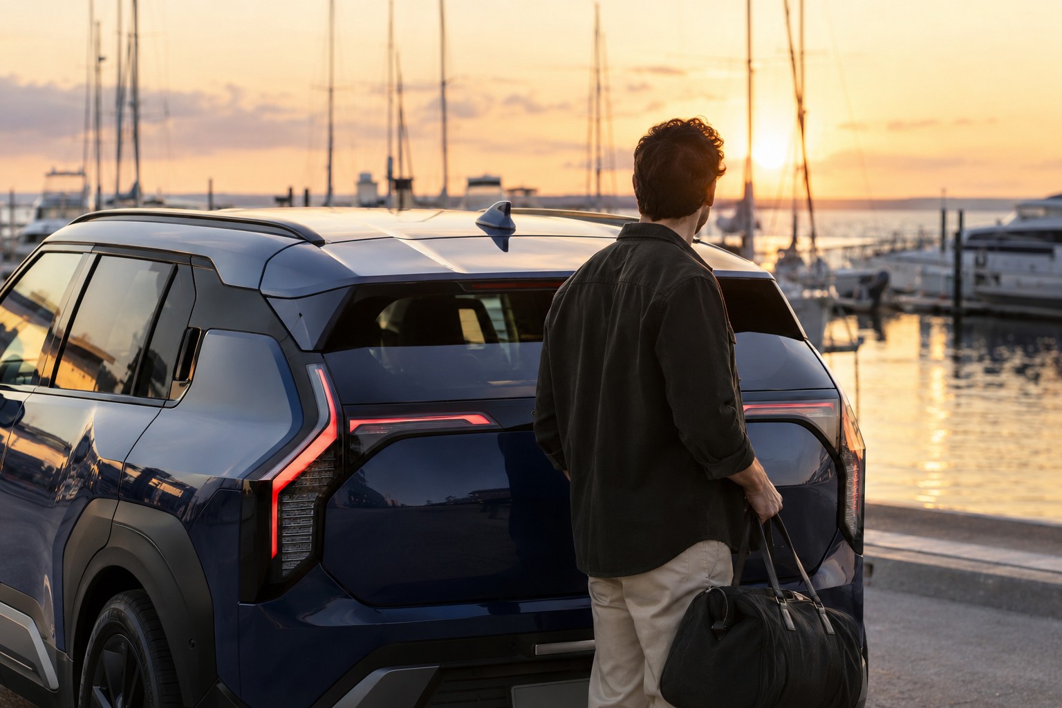 Kia EV3 Autoversicherung: Kia EV3 GT und GT-line nicht verwechseln Mann mit Reisetasche hinter einem blauen Kia EV3 an einem Hafen