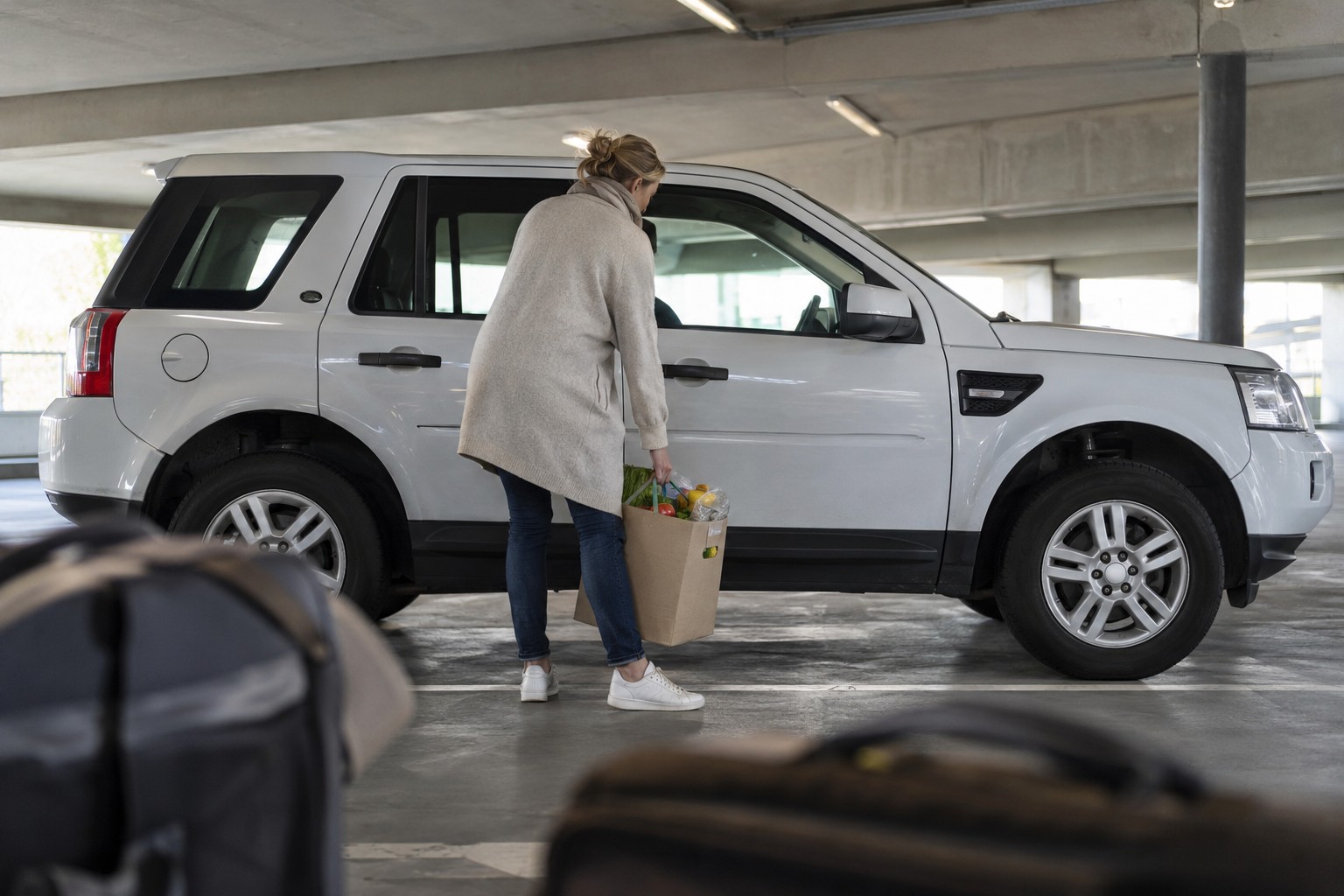 Land Rover Freelander: Freelander und Discovery Sport sind eigene Baureihen, auch wenn beide für ähnliche Aufgaben genutzt werden. Weißer Land Rover Freelander in einem hellen Parkhaus neben Einkaufskartons