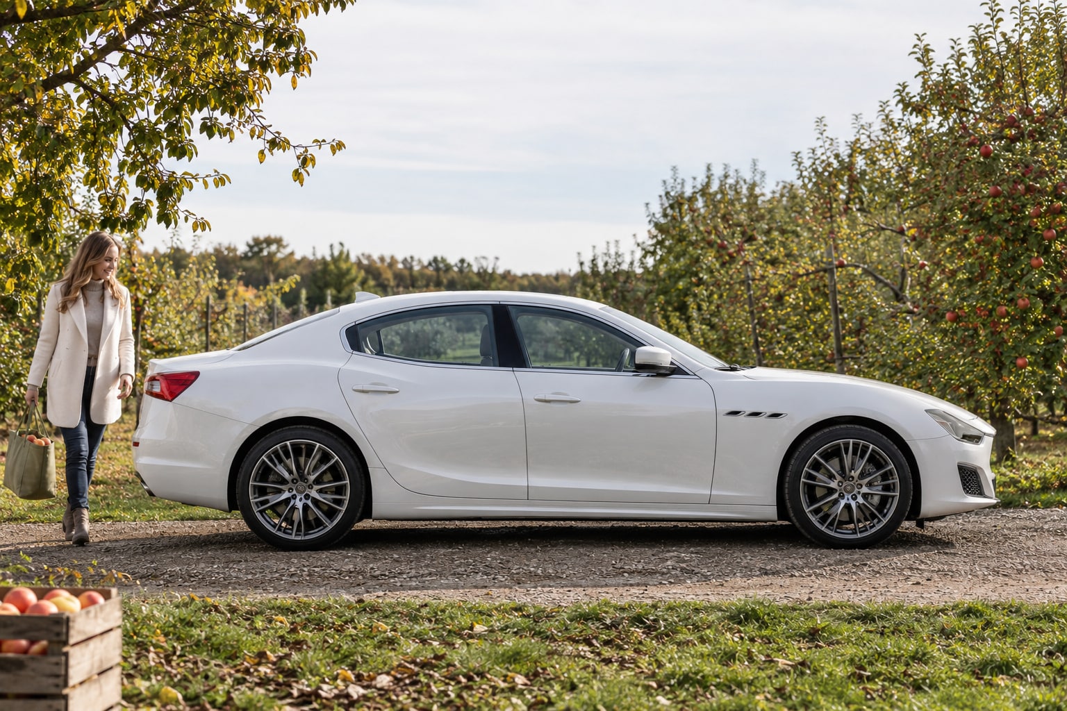 Maserati Autoversicherung: Kaskoschutz nach Modell, Antrieb und Ausstattung vergleichen. Weiße Sportlimousine vor einem Garten: Maserati Autoversicherung