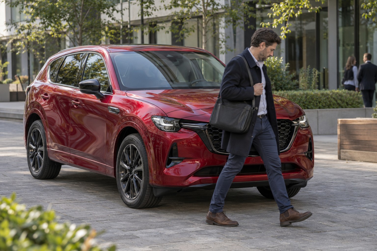 Mazda CX-60 – Plug-in-Hybrid und Reihensechszylinder Mann mit Tasche vor einem roten Mazda CX-60 in einem Bürohof