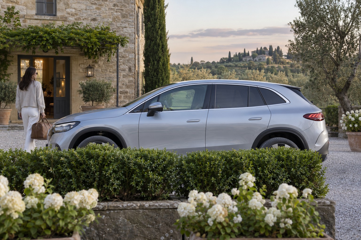 Mercedes-Benz EQE SUV – Fahrzeug und Versicherung Mercedes-Benz EQE SUV im Seitenprofil; silberner Wagen mit natürlichen Vordergrundpflanzen