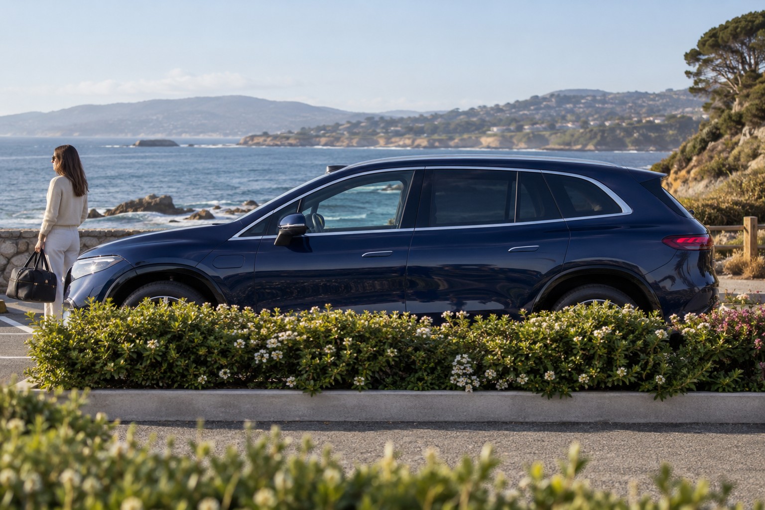 Mercedes-Benz EQS SUV im Seitenprofil; dunkelblauer Wagen mit natürlichen Vordergrundpflanzen