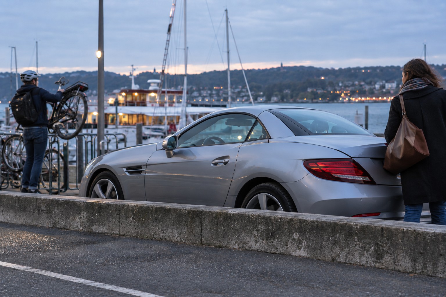 Mercedes-Benz SLK und SLC Versicherung: Roadster und Verdeck Silberner Mercedes-Benz SLC an einem Hafen mit Fahrrad und Gepäck