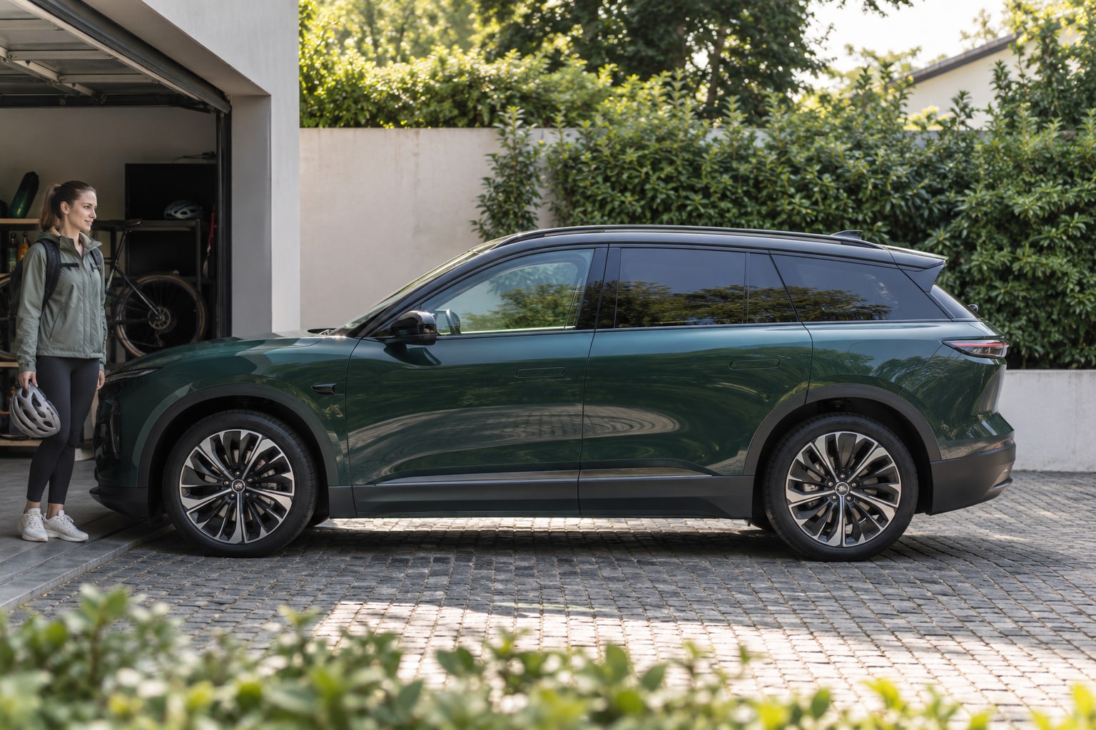 Nio EL6 Autoversicherung: elektrischen SUV und Batterie-Vertragswahl gemeinsam erfassen. Grüner SUV mit Paar vor einer Garage: Nio EL6 Autoversicherung