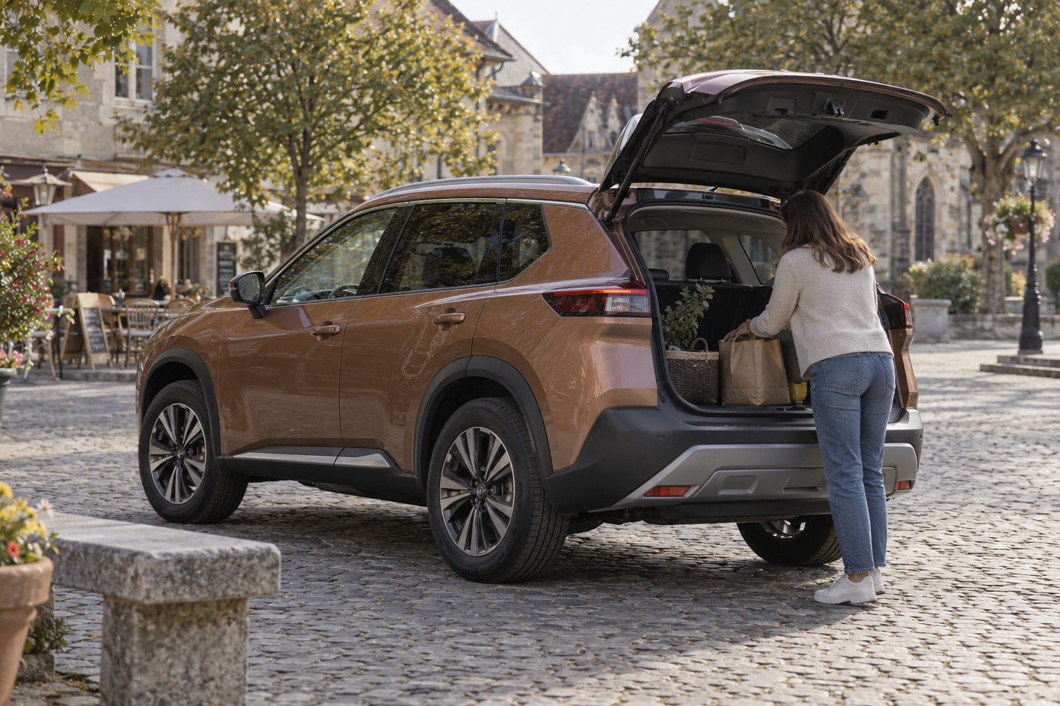 Frau lädt Gepäck in einen kupferfarbenen Nissan X-Trail auf einem Stadtplatz