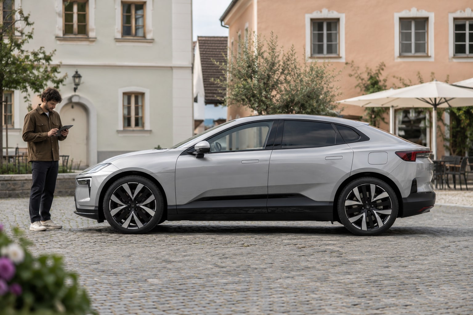Polestar 4 Autoversicherung: Karosserie und Heckkonzept vor dem Tarifvergleich bestimmen. Silberner großer Elektro-Crossover auf einem Stadtplatz: Polestar Polestar 4 Kfz-Versicherung