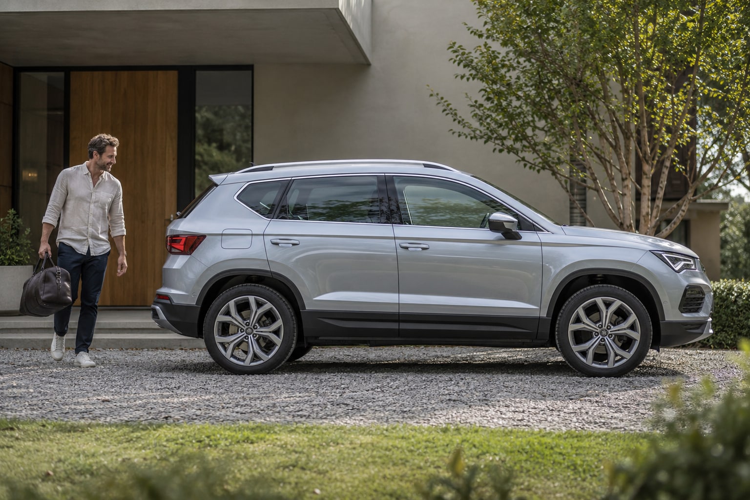 SEAT Ateca Kfz-Versicherung: Bei einem Lagerwagen Erstzulassung, Fahrzeugzustand und Neupreisbedingungen prüfen. Silberner SUV mit Mann auf einer Einfahrt: Seat Ateca Kfz-Versicherung