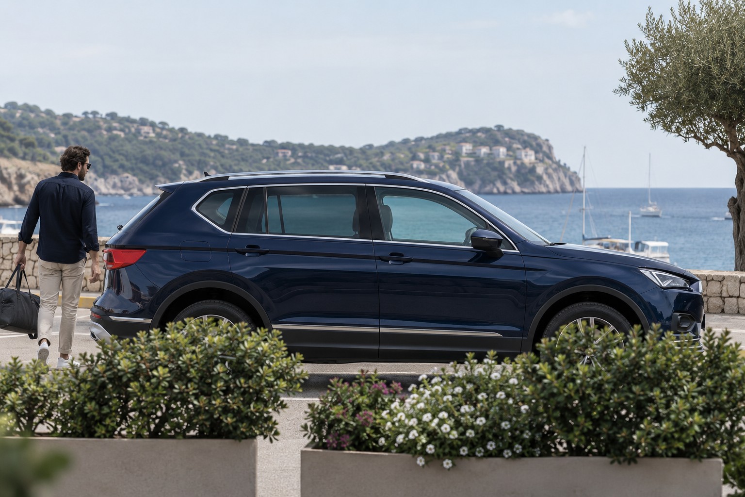 SEAT Tarraco – Fahrzeug und Versicherung SEAT Tarraco im Seitenprofil; dunkelblauer Wagen mit natürlichen Vordergrundpflanzen