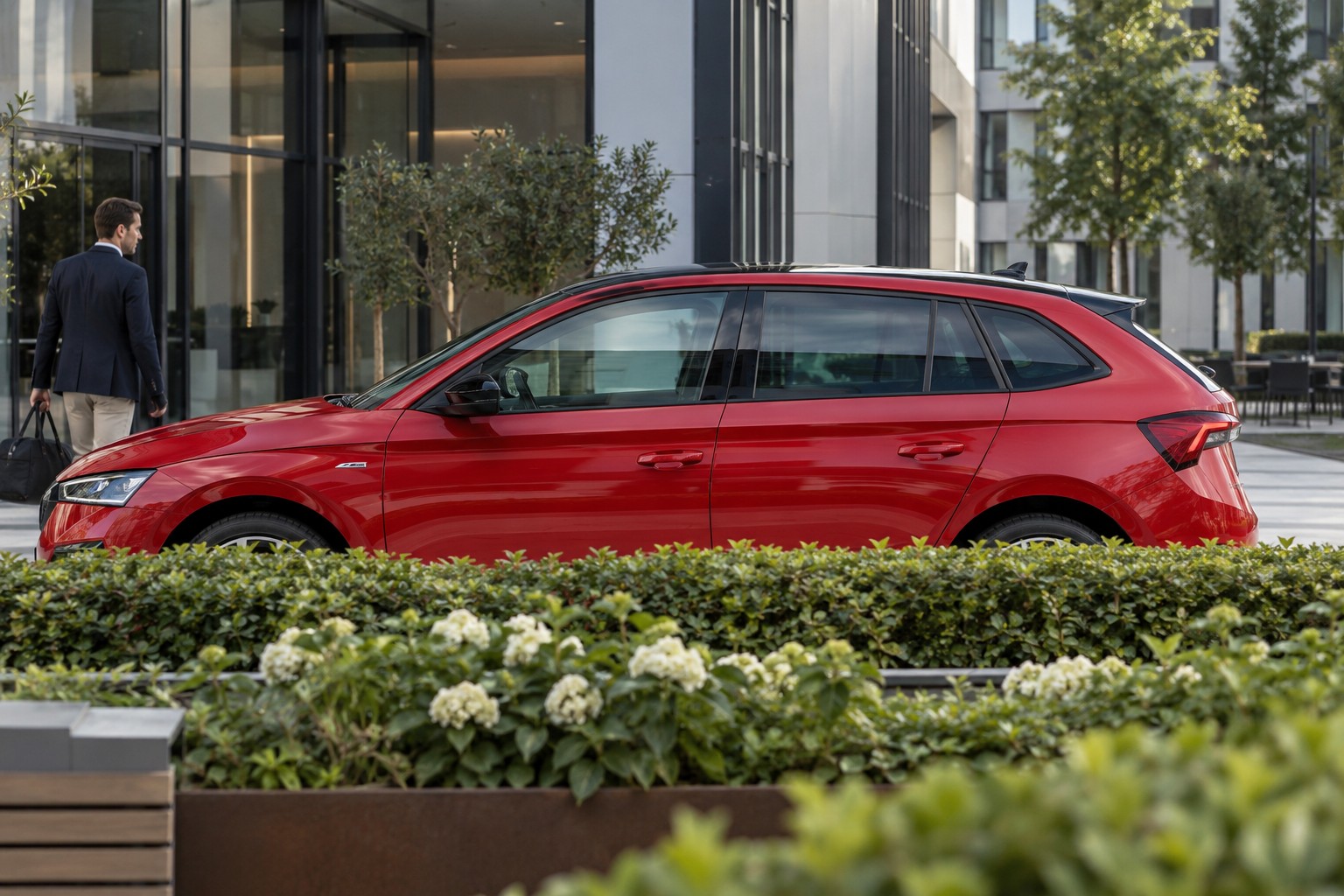 Škoda Scala Monte Carlo – Fahrzeug und Versicherung Škoda Scala Monte Carlo im Seitenprofil; roter Wagen mit natürlichen Vordergrundpflanzen